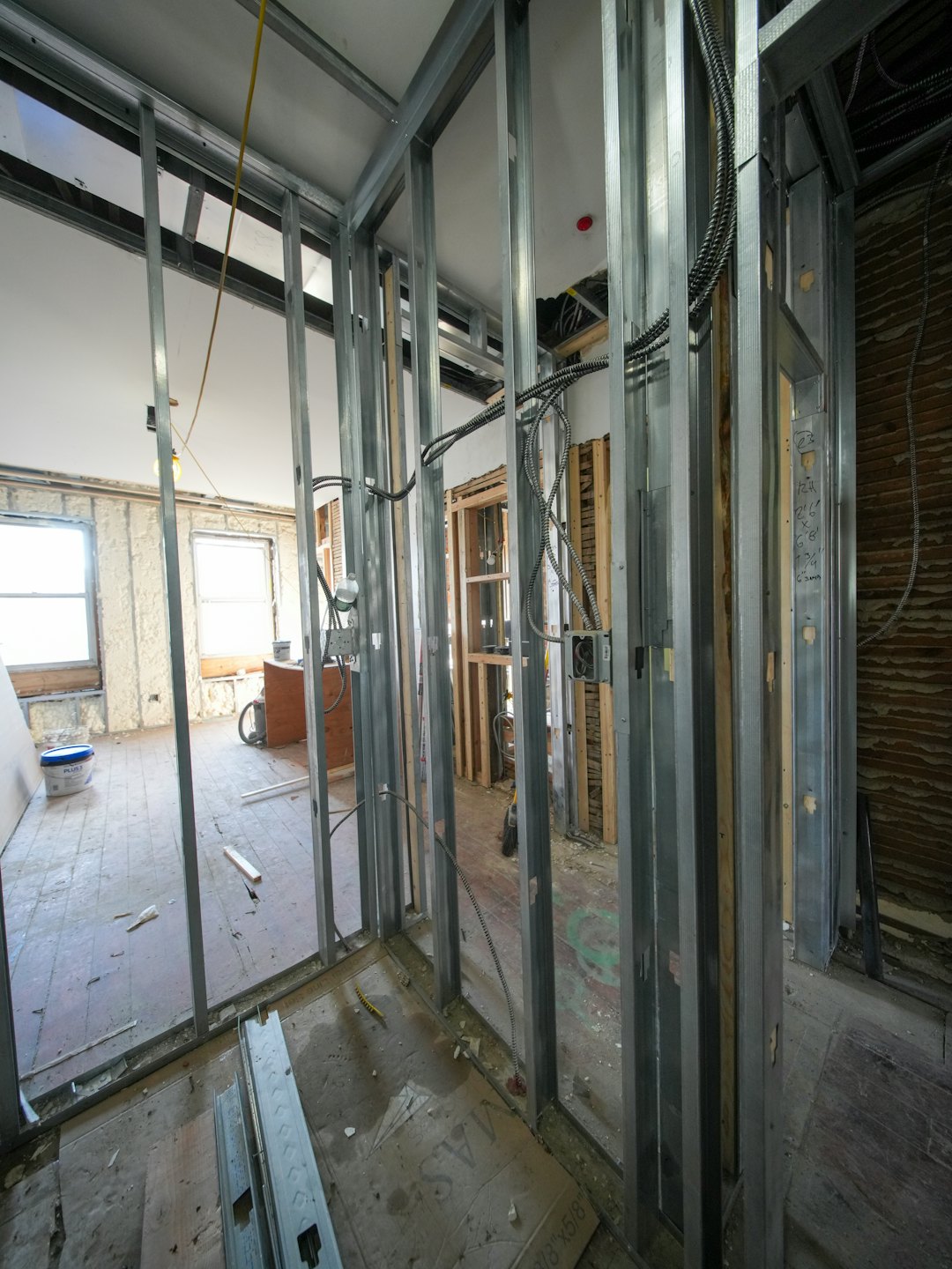 Interior construction site with metal studs and exposed wiring.